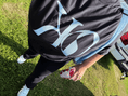 Load image into Gallery viewer, KO Creative Agency Logo Tee with only KO. On Kaitlin on a black tee with light blue letters. Kaitlin is outside and carrying a drink.
